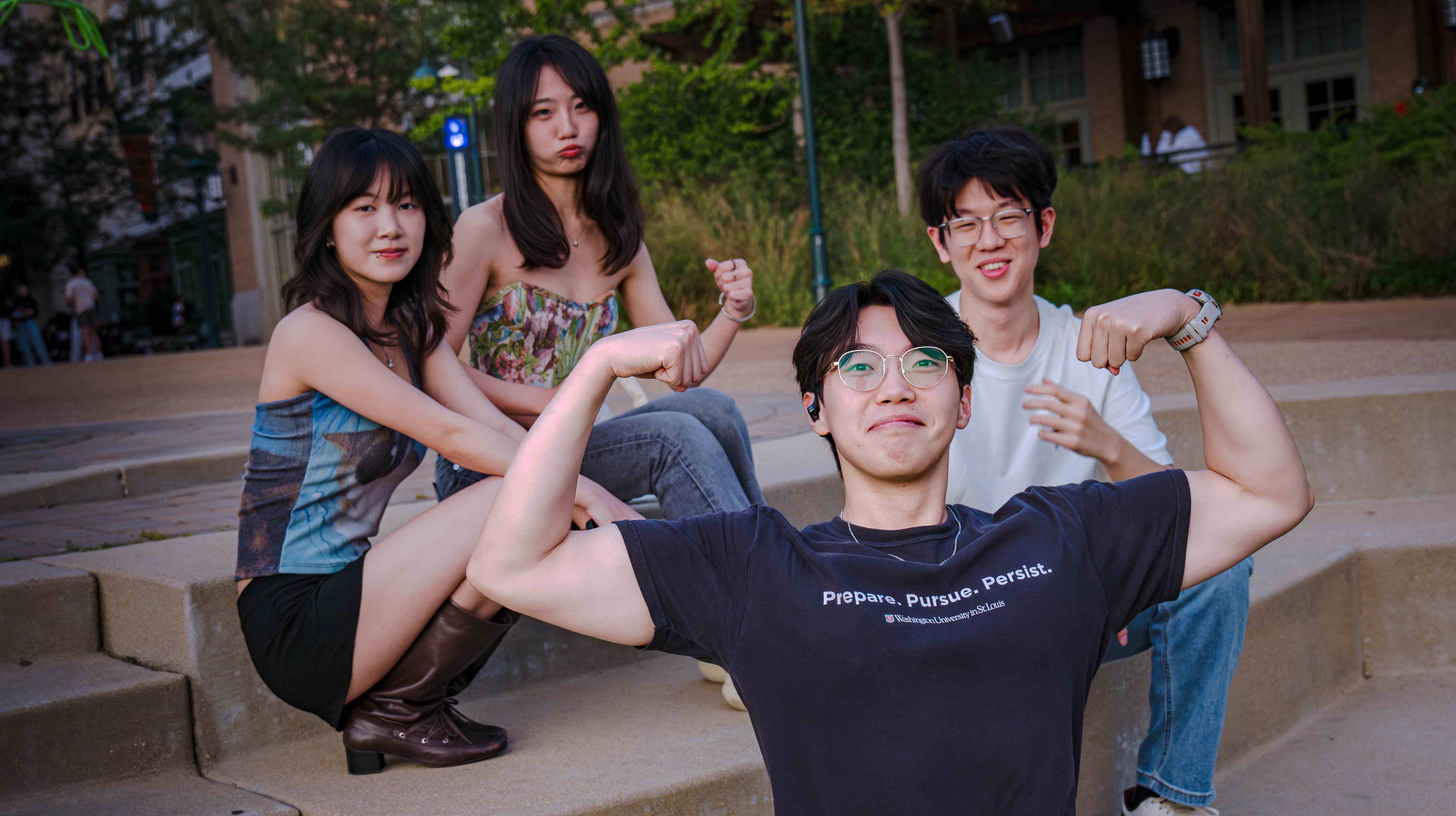 乐队成员在台阶上的合影,前景男生做强壮手势